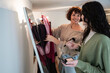 © ADDICTIVE STOCK - Friends choosing outfit in closet while doing makeup