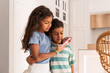© ADDICTIVE STOCK - Hispanic siblings using smartphone together at home