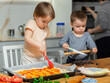 © JackF - Toddler girl and boy cook pizza with mom in kitchen. Children help mother, they are passionate about kitchen chores, learning through practical work..