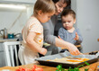 © JackF - Family are cooking italian pizza together in cozy home kitchen. Cute kids with happy mother are preparing food or meal for dinner