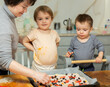 © JackF - Exciting activity for kids is working with dough. Boy and girl participate in preparation of pizza, help mother in kitchen..
