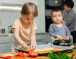 © JackF - Mother teaches her two young sons how to make homemade pizza in cozy kitchen