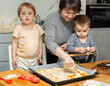 © JackF - Toddler girl and boy cook pizza with mom in kitchen. Children help mother, they are passionate about kitchen chores, learning through practical work..