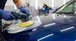 © Tiaga - Hands of car service worker with orbital polisher polishing car hood in repair shop. Procedure of detailing and valeting car at the service