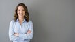 © Your Stocks  - Successful professional woman standing with arms crossed and friendly smile against gray wall copyspace, entrepreneur