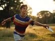 © TE - Joyful action of a young boy throwing a ball in a sunlit park capturing outdoor recreation and playful energy
