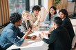 © chokniti - Business meeting office team diverse people discussion collaboration planning strategy professional group collaborate around table bright modern office, focused conversation and teamwork with