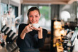 © chokniti - Woman coffee cup smiling cafe barista portrait friendly service counter beverage drinking shop interior