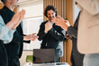 © chokniti - Business team celebrating success in office happy diverse professionals raising hands teamwork achievement corporate victory collaboration motivation workplace energy