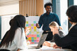 © chokniti - Business team meeting discussion collaboration presenting data analysis corporate teamwork diverse professionals planning strategy office communication partnership