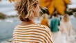© Pinklife - A woman in a striped top walking towards a group of people by the water, surrounded by stunning autumn foliage, portraying the beauty of nature and companionship.