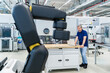 © Westend61 - Engineer with laptop in modern factory with industrial robot arm