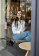 © Westend61 - Smiling freelancer working with a laptop indoors at a cafe