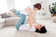 © deagreez - Mother playing with daughter on the living room carpet, joyful family bonding and playful parent-child moment at home