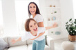 © deagreez - Happy mother and daughter playing airplane in a bright living room — joyful family moment of bonding, play and laughter at home