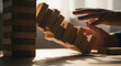 © Jabalenour - Hands trying to stop falling wooden blocks tower from collapsing
