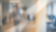 © Vhagar - A blurred view of a busy office environment, showcasing people working in the background. The image conveys a dynamic and modern workplace setting.