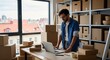 © TryOut - Man working on laptop surrounded by cardboard boxes in a warehouse or storeroom, small business