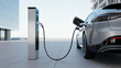© Sohagi - Modern electric vehicle charging at public station outdoors next to corporate office building in daytime while plugged into port on gray car representing sustainable transport and green energy use.