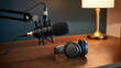 © Sohagi - Podcast microphone and headphones set up on wooden desk with lamp in background symbolizing audio recording and content creation for broadcasting and sound production.