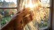 © 24DIY - Hand holding bundle of optical fibers illuminated by bright sunlight through a window