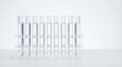 © 24DIY - Ten clear glass test tubes filled with clear liquid arranged in a rack