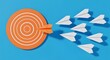 © Mirza Hakim - Goal achievement concept, orange target with paper airplanes, symbol of focus, accuracy and goal driven direction