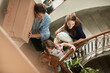 © Marko Geber - Smiling family carrying moving boxes in apartment stairwell