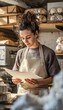 © spyrakot - Vertical baker in neutral workwear checking plain financial papers in prep kitchen with unlabeled pa