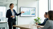 © Xenia - Smiling businesswoman presenting financial charts on a screen in a modern office. Professional female employee explaining data to colleagues during a corporate meeting