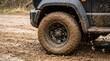 © ridho - Muddy SUV tire on off-road terrain