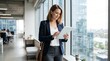 © ameliadimufah - Professional businesswoman using tablet in modern office with city skyline view