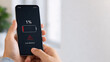 © s - スマートフォンのバッテリー残量1％の警告表示と手元のクローズアップ｜低電力・電池切れ・充電不足・モバイルデバイスの電力問題