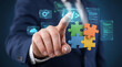 © zabhie - Businessman touching coding icon with colorful puzzle pieces, custom software development and system integration concept, modular application programming and cloud technology