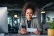 © Alena - Happy young professional woman looking at her first paycheck and smartphone screen with joy smiling female employee celebrating first salary deposit in modern office finance and career success concept