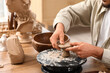 © Pixel-Shot - Young male sculptor shaping clay figure on pottery wheel in workshop, closeup