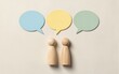 © YiuCheung - Two wooden figures face three colorful speech bubbles symbolizing