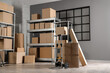 © Pixel-Shot - Interior of warehouse with shelf units, cardboard boxes and trolley