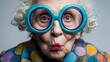 © wilson - Funny portrait of senior elderly woman with big turquoise round glasses, puckered lips and colorful polka dot shirt