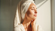 © Kowit - A woman with a towel wrapped around her head enjoys sunlight, appearing relaxed and refreshed after bathing.
