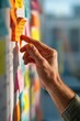 © backup_studio - Man pointing at sticky note on whiteboard for project management. Professional manager organizing workflow with adhesive paper in office. Collaborative brainstorming and team planning session.