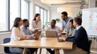© benjamin - A diverse group of business professionals actively engage in a collaborative meeting around a large table in a modern office space.