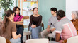 © JackF - Male and female colleagues of various ages and nationalities friendly talking sitting in circle on chairs in office lounge during break