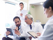 © .shock - Middle Eastern doctors discussing patient care in a hospital meeting with tablets and medical notes