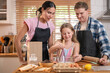 © Wosunan - In holiday, Happy family baking together in the kitchen, parents teaching child to prepare dough
