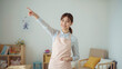 © bephoto - 明るい保育室で日本人女性保育士が子育て情報を笑顔で示す写真