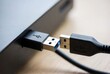 © Kitta Studio - Close-up of blue USB 3.0 cable connector plugging into a black port on a device