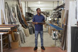 © 24K-Production - African American metal factory manager taking inventory using a tablet for modern, digital supply chain management in heavy industry.
