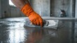 © Masque - Construction worker using a float to smooth wet self-leveling compound on a concrete floor.