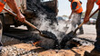 © InfinityVisuals - Road Repair Crew at Work: A construction crew works diligently on a road repair project, shoveling hot asphalt into a pothole. Steam rises from the material as the workers.